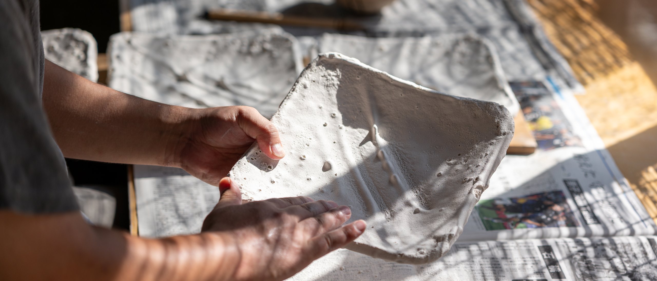 Hands holding a freshly glazed plate